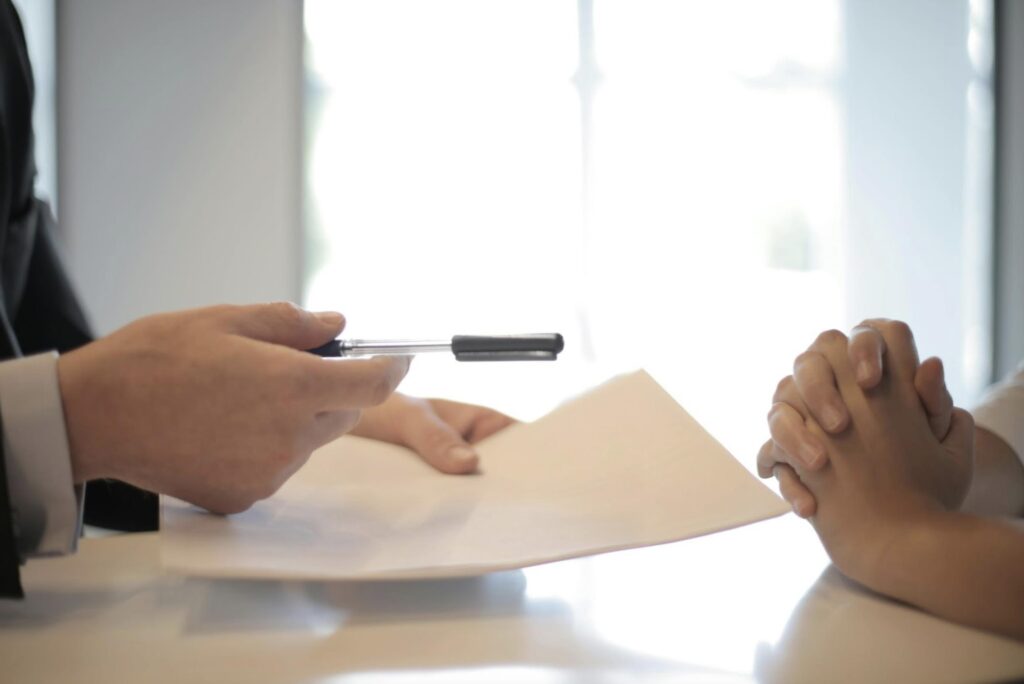 A finance broker handing over personal loan documents to be signed.