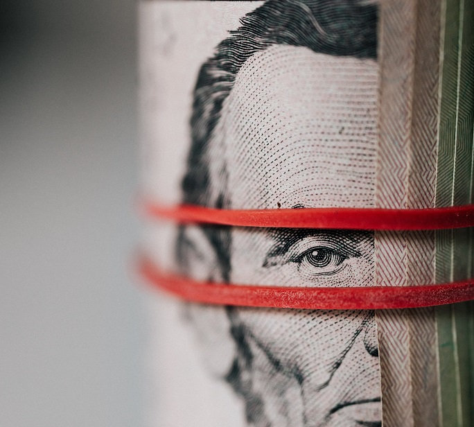 Know Your Secure and Unsecured loan rates dollar notes secured with a red elastic band