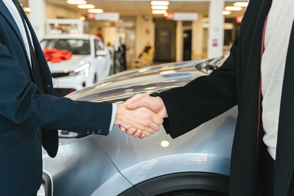 shaking hands over a car loan agreement